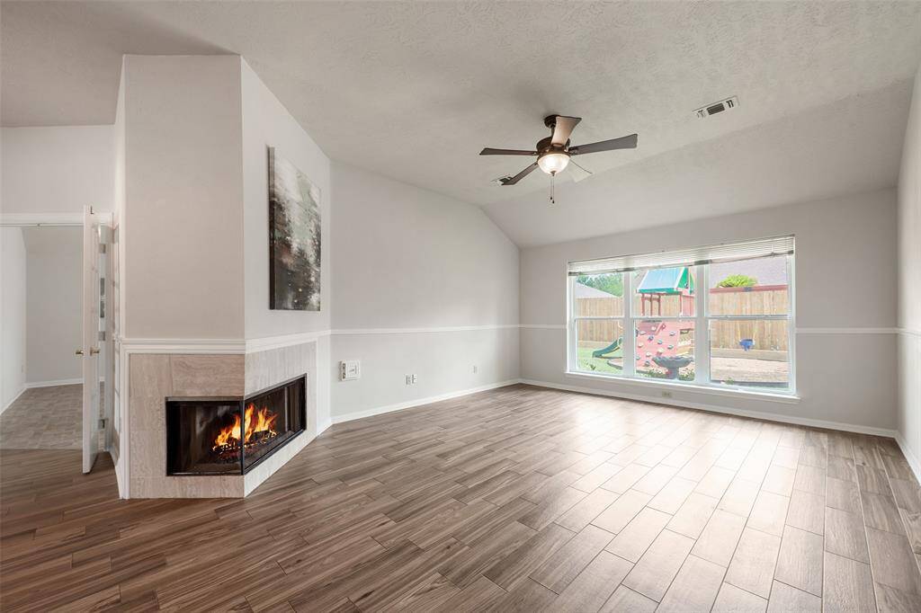 Family room with tile framed gas log fireplace with views from 2 sides - very aesthetically appealing!