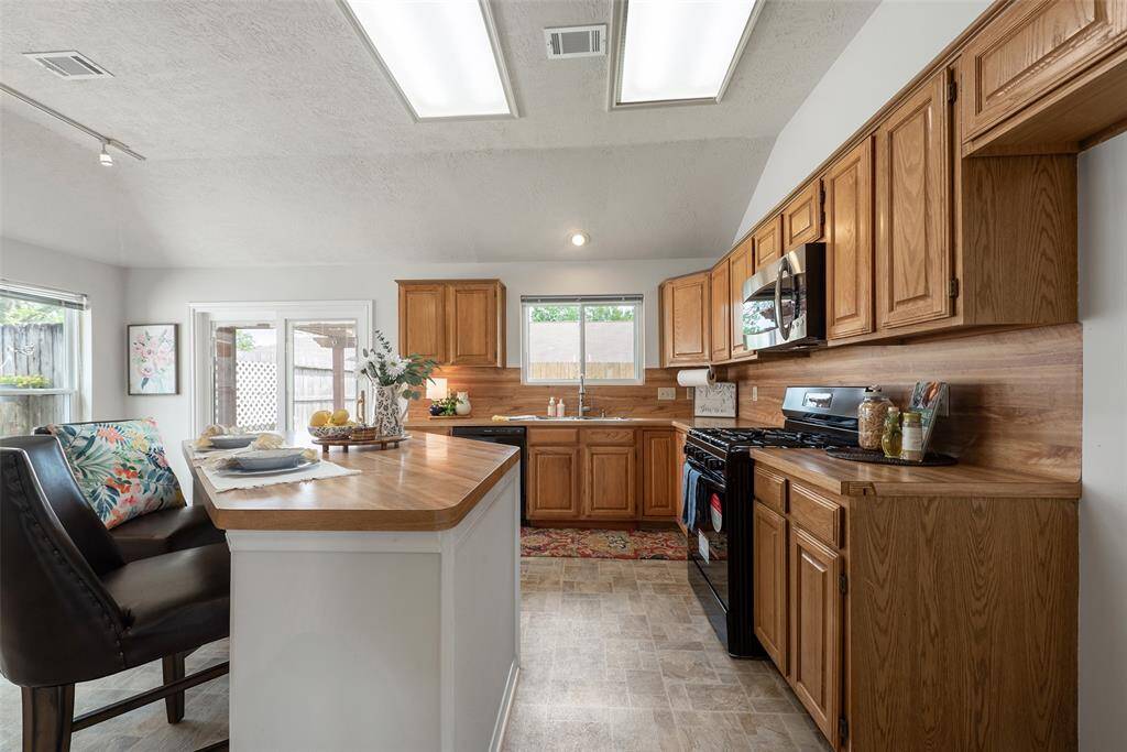Beautiful kitchen with abundance of cabinet storage space, attractive countertops, complimenting backsplash, gas stove & a large island with space for adding bar stools.