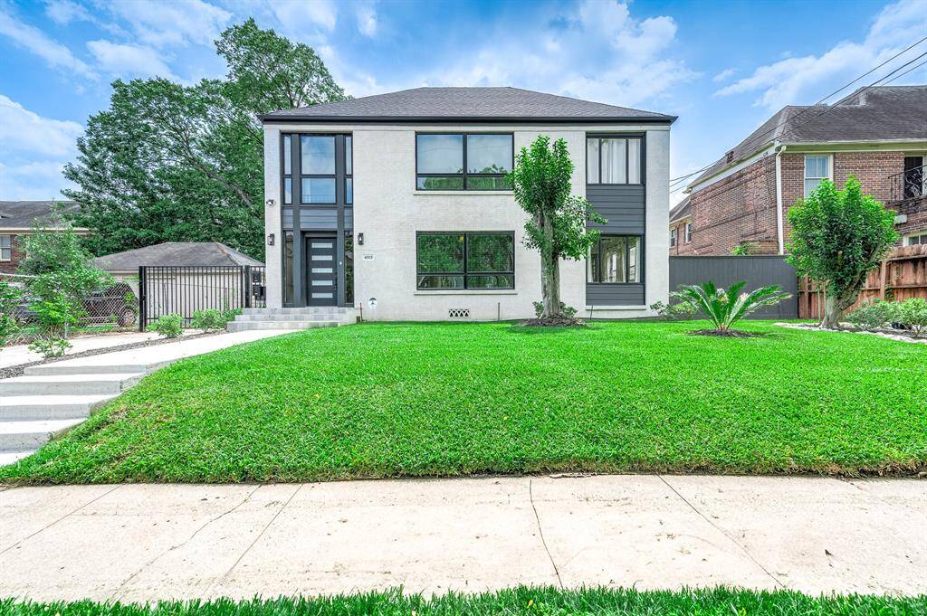 sleek white exterior and expansive windows that flood the space with natural light. Features a well-kept front lawn, a clean concrete walkway, and is nestled in a quiet residential neighborhood. Prime location just minutes from the Museum District and the Texas Medical Center.