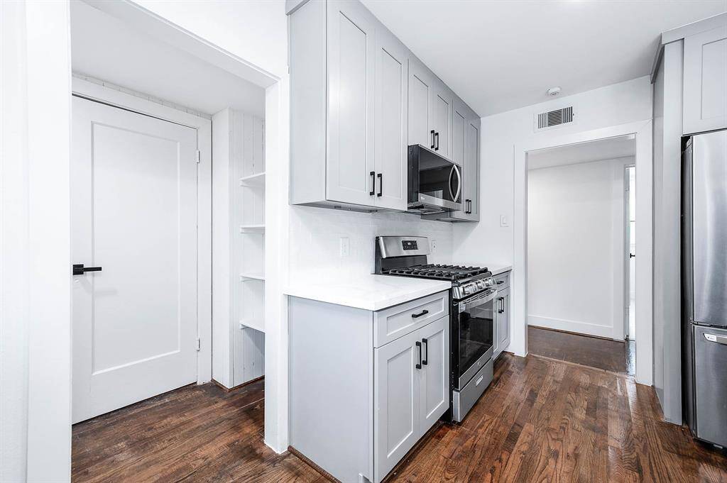 To the left, you'll find additional shelving and a door leading to the backyard, while a hallway to the right takes you to the bedrooms.