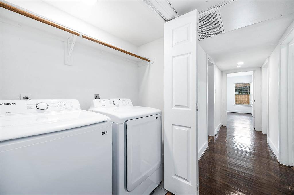 Laundry area featuring a NEW washer and dryer set tucked into a closet, complete with a wooden hanging rod for added convenience.