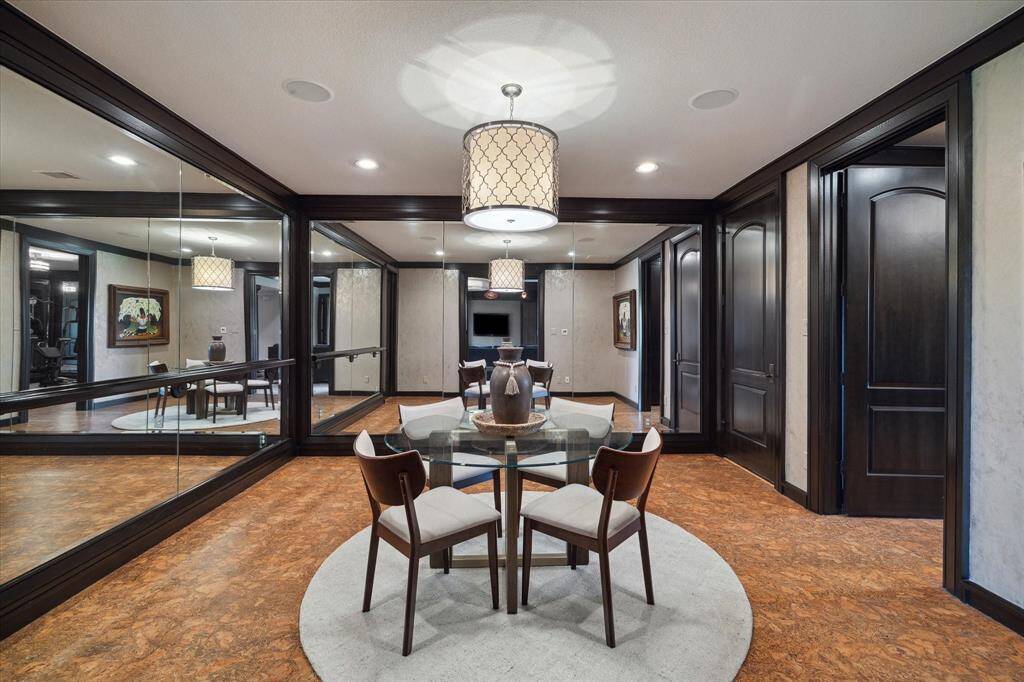 Once envisioned as a dance studio, this versatile mirrored flex space is brimming with potential—ideal for everything from dance practice and puzzle building to lively poker nights. The sound-absorbing cork flooring provides both warmth and comfort, while floor-to-ceiling mirrors and refined trim enhance the sense of space and light. Additional highlights include built-in speakers, a spacious walk-in closet, attic access, and a stylish drum chandelier that anchors the room.