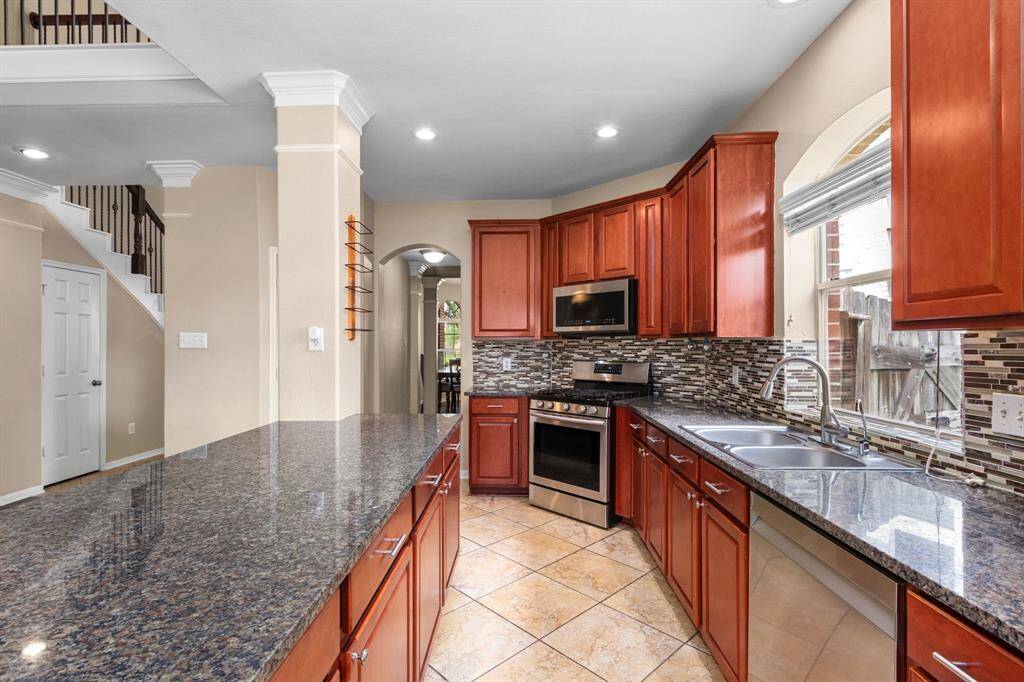 This well-planned kitchen provides ample cabinet storage and abundant countertop prep space for meal planning, serving, or even homework. The island/breakfast bar opens into the living room, providing clear sight lines for the chef in the household.