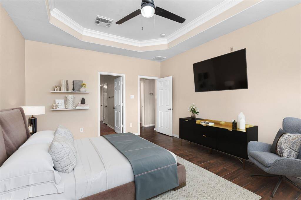 The tray ceiling, extended sitting area, and spacious layout create a relaxing and welcoming primary bedroom.