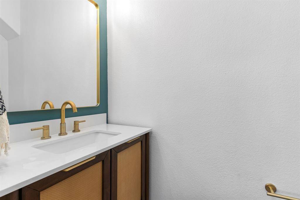 The first-floor powder room has been recently updated with a new vanity, hardware, mirror, and designer paint.