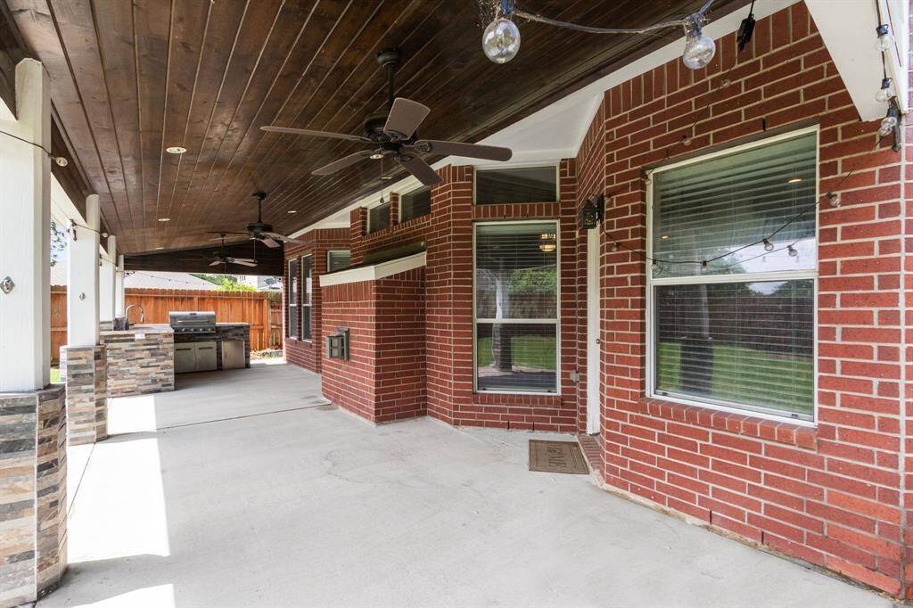 The extended covered patio features an impressive wood treatment on the ceiling and fans to keep you comfortable as we head into summer. There is space here for lounging and dining furniture, and the summer kitchen is ready for use!