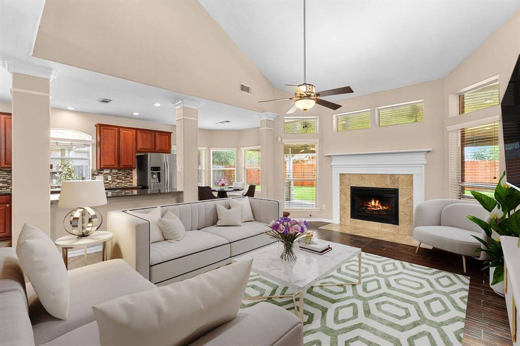 Open concept floorplan with views from the living room to the kitchen, breakfast room, and outdoor patio/summer kitchen. This spacious layout allows you the option to enjoy cozy nights in front of the fire, or entertain large groups. Updated ceiling fan and abundant natural light from the well-placed windows are hallmarks of this space. Enjoy a casual meal at the breakfast bar, or use that expansive island as a serving buffet for larger gatherings.