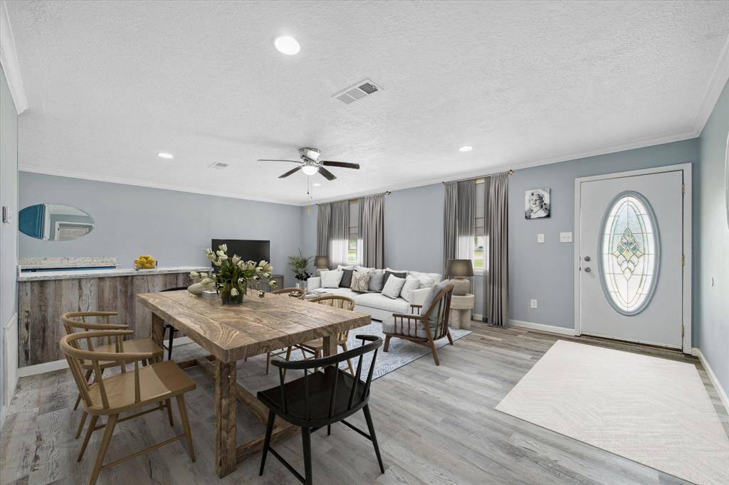This aerial photo showcases a residential property with a brick house and a spacious yard, located near a waterfront with a clear view of the surrounding neighborhood and easy access to nearby roads.