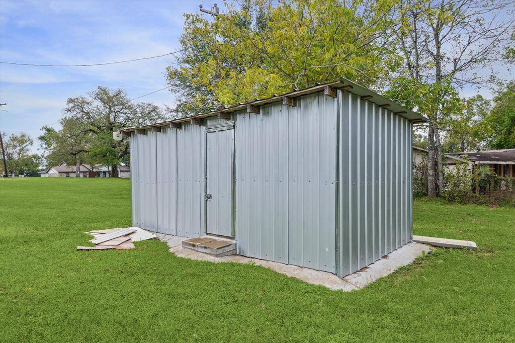 This is a single-story brick home with a spacious, well-maintained lawn and a mature tree.