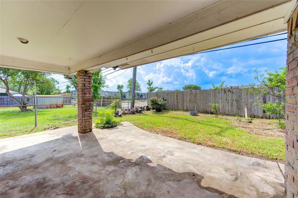 Spacious covered patio perfect for relaxing and enjoying the outdoors, with a view of the lush backyard.