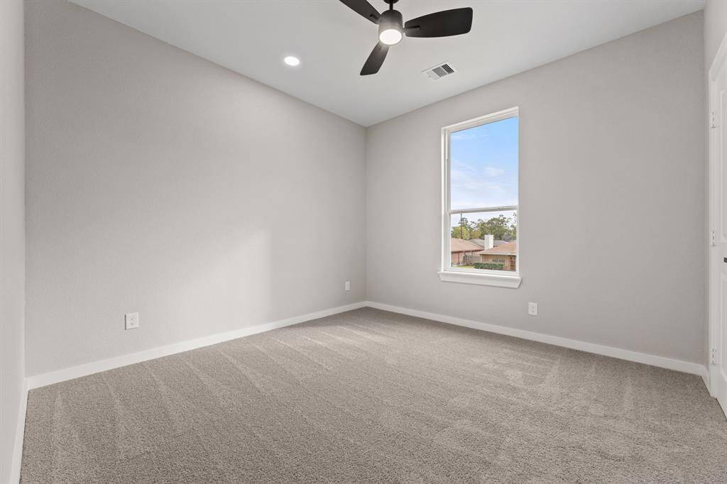 First bedroom with ample space. Whether for a guest room or home office, this bright room is versatile for your needs.