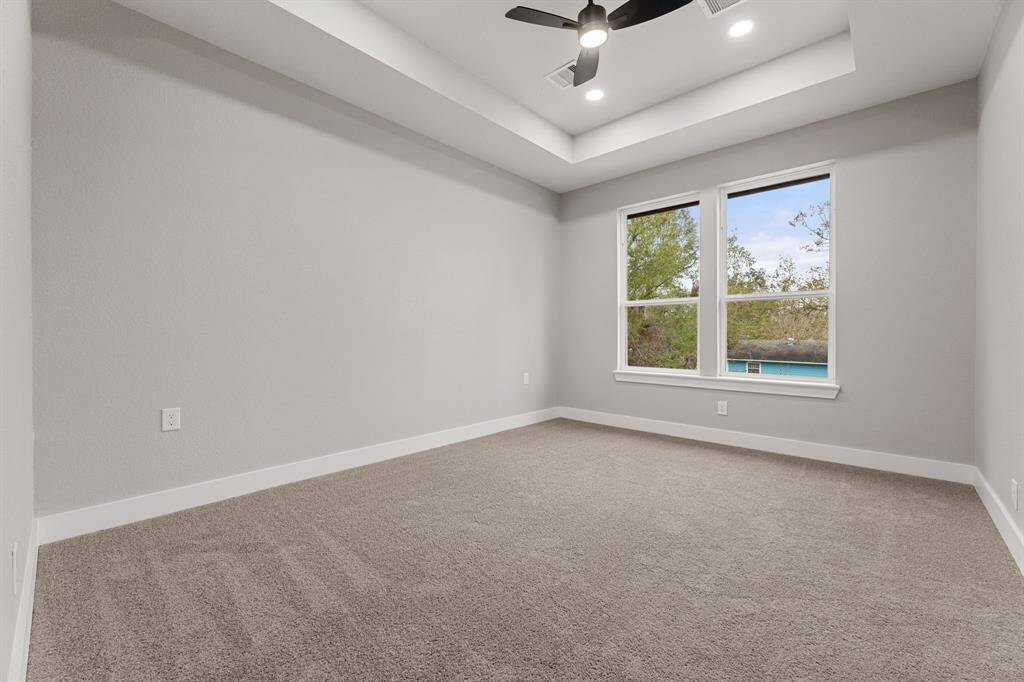 Welcoming primary bedroom. This large bedroom offers recessed lighting, a contemporary tray ceiling, and plenty of space to unwind.