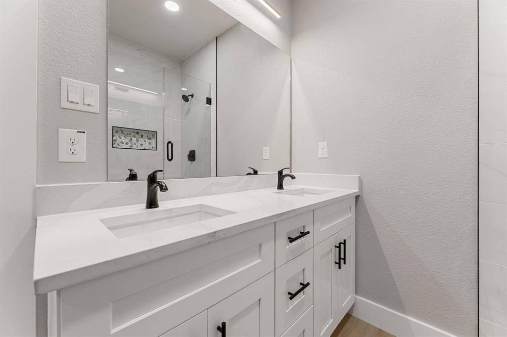 Start your day in style! The elegant primary bathroom features a walk-in shower, double sinks, and sleek quartz countertops.