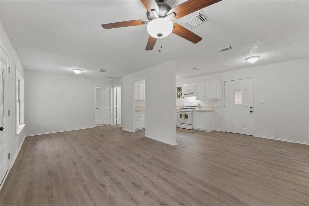 Spacious and bright living room with ceiling fan, seamlessly connected to the kitchen for effortless entertaining.