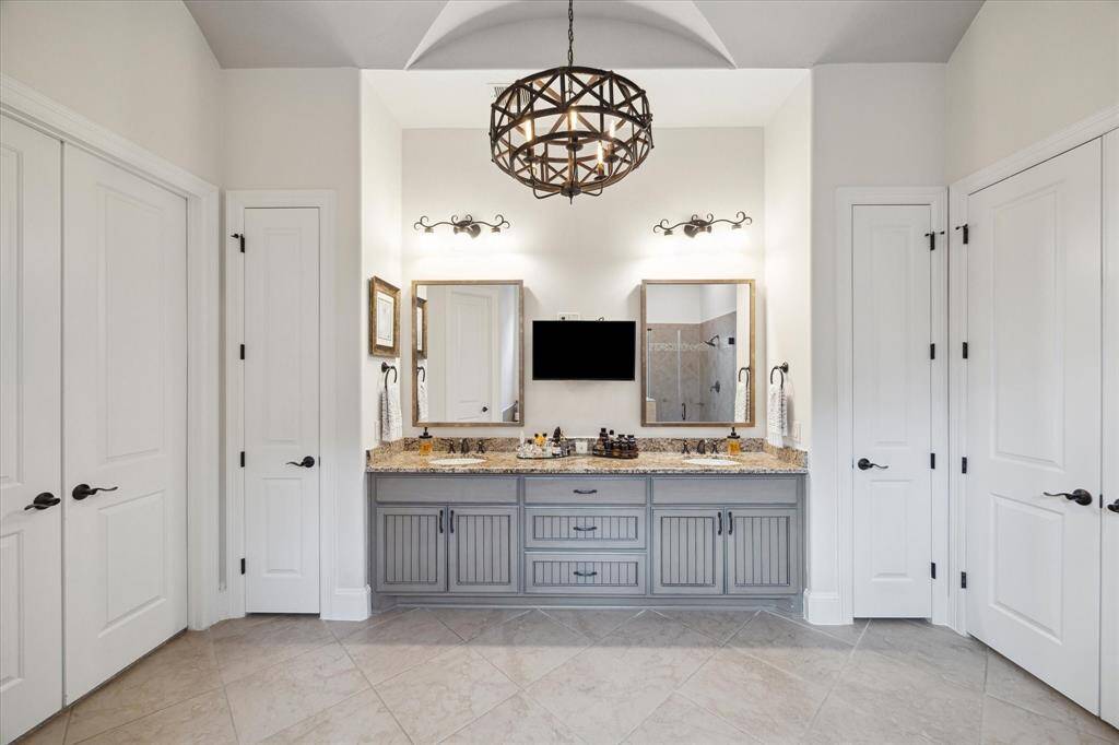 Primary Bath with double vanities and plenty of storage. Chandelier showing in photo has been changed out.