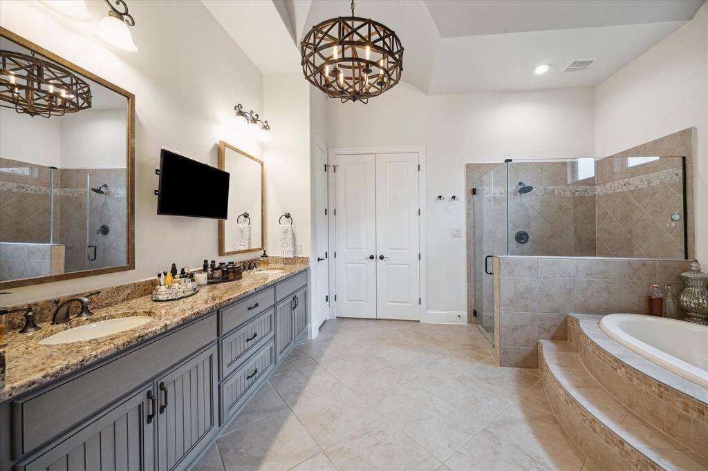 Spa-Like Primary Bath with walk in shower and soaking tub. Chandelier showing in photo has been changed out.