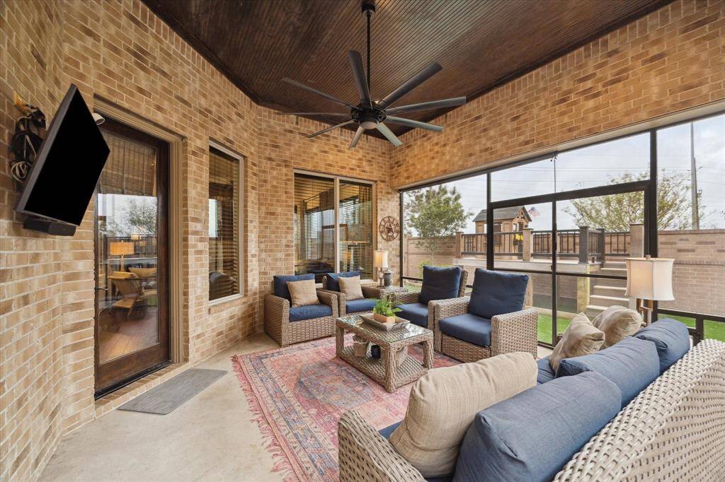 Enjoy the outdoors year round from this screened in rear porch with stained wood ceiling.