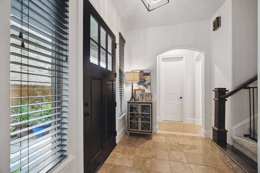 Foyer with travertine floors and decorative tile borders.