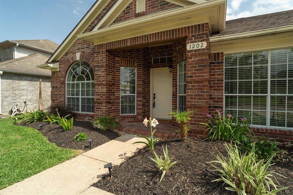 FRESHLY MULCHED FLOWERBEDS, COVERED FRONT PORCH