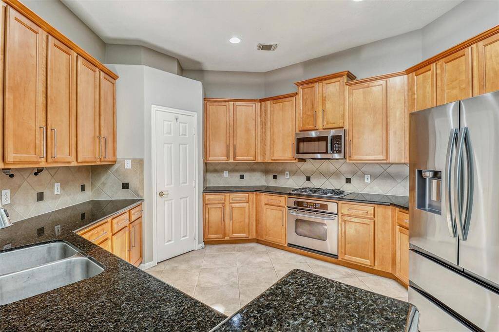 Wrap-around cabinetry offers ample storage for all your kitchen essentials, while a spacious pantry provides even more room for organization and convenience.