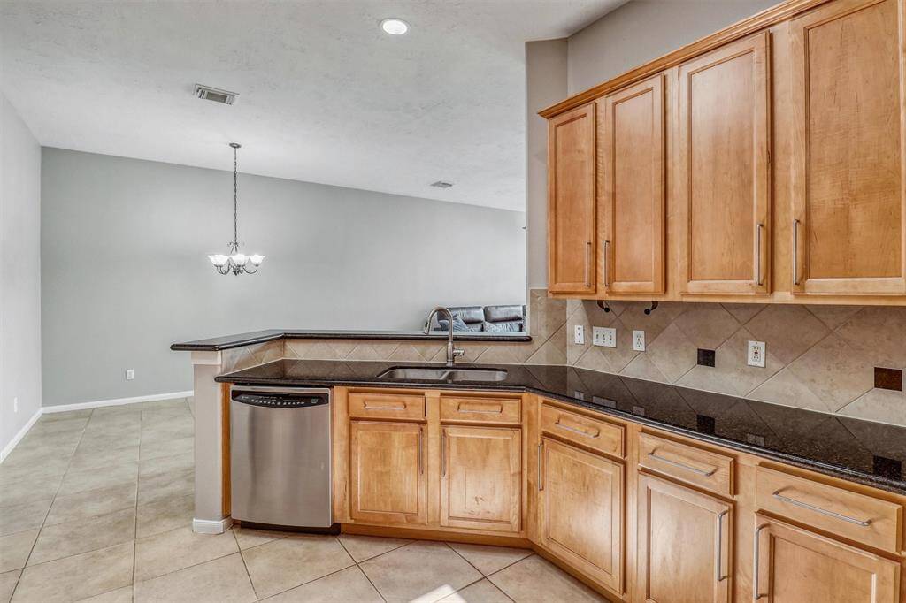 The undermount sink is thoughtfully positioned beneath the expansive breakfast bar, allowing for effortless entertaining and conversation while working in the kitchen. For added convenience, the dishwasher is located just to the left of the sink.