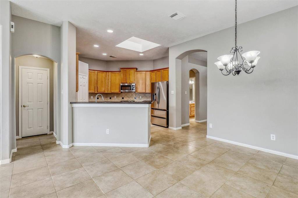 The breakfast bar offers a convenient dining option with space for a few bar stools, while the kitchen seamlessly overlooks both the breakfast area and the living room, creating an open and inviting flow.