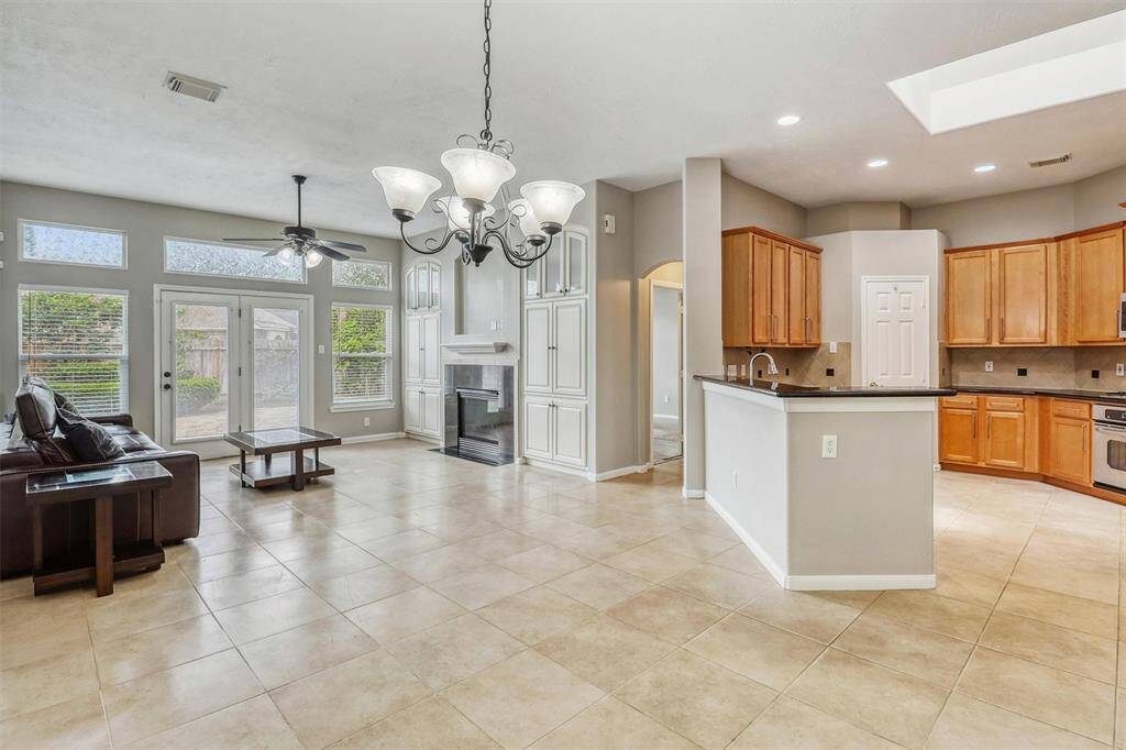 The windows in the living room, overlooking the backyard, flood the breakfast area with natural light, making it the perfect spot for a round table and chairs to enjoy casual meals.