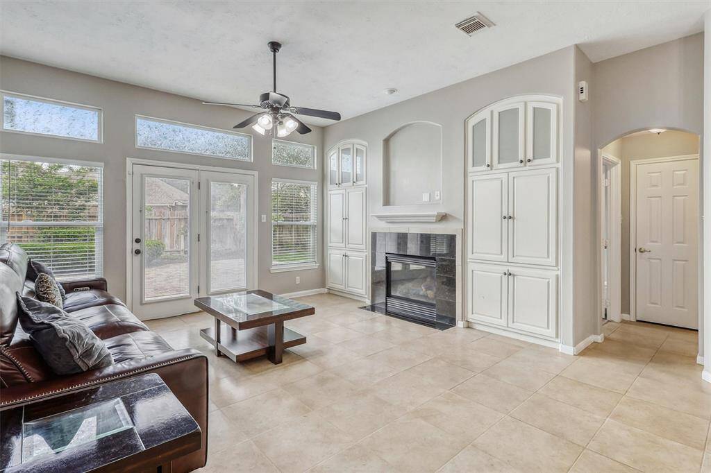 This stunning living room is a true showstopper, featuring a wall of floor-to-ceiling windows, custom built-ins, and a cozy fireplace—combining style and functionality for the ultimate living space.