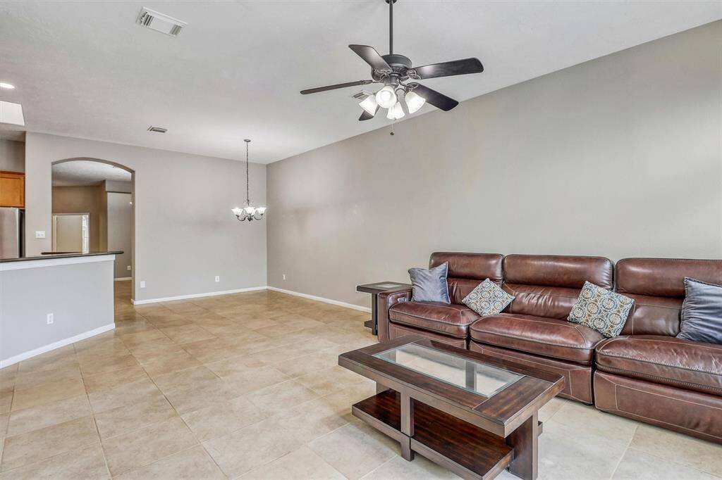 This open-concept layout is ideal for entertaining, offering plenty of space for a large sectional, sofa and loveseat, and a coffee table—perfect for hosting guests or relaxing with family.