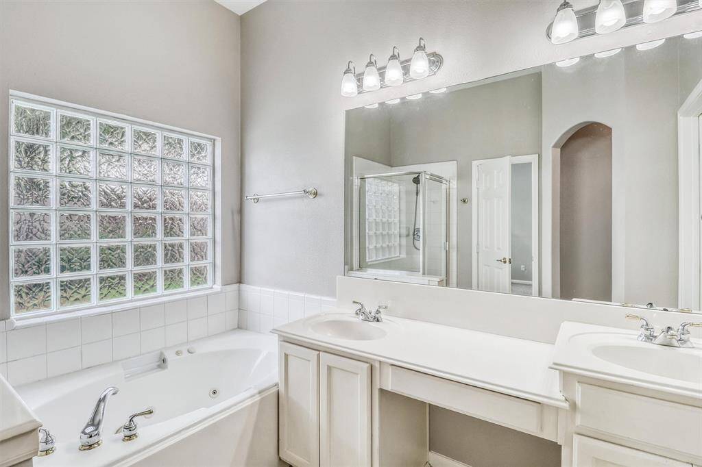 The vanity is equipped with dual sinks, polished nickel finishes, and a convenient seating area—ideal for getting ready for the day in comfort and style.