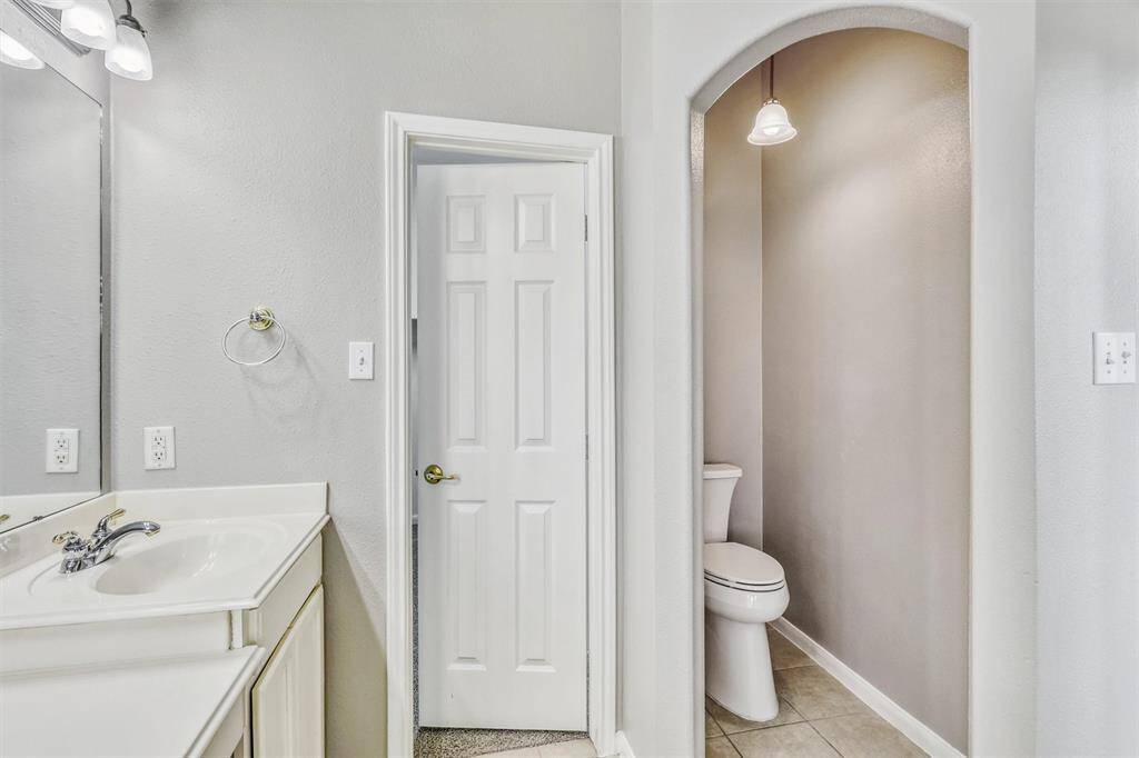 The commode is thoughtfully tucked away for added privacy. Beyond the doorway, you'll discover a spacious walk-in closet, providing ample storage for your wardrobe.