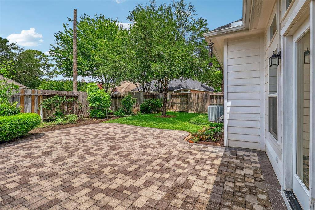 There’s also plenty of space for a grill or an outdoor kitchen setup! The mature shrubs that frame the backyard add privacy and enhance the natural beauty of the space.