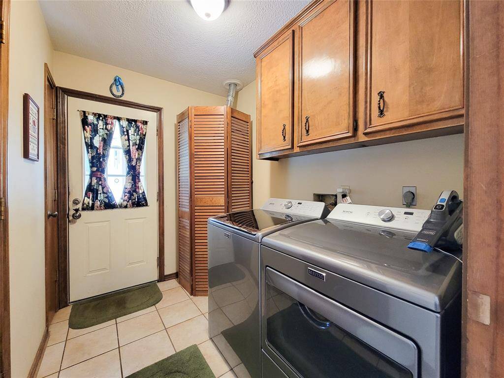 Utility room or mud room exits to the back yard. There are electric and gas connections for the dryer.