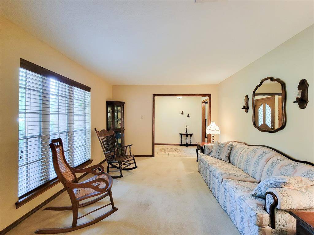 This cozy living room features a large window with blinds that allows for ample lighting.