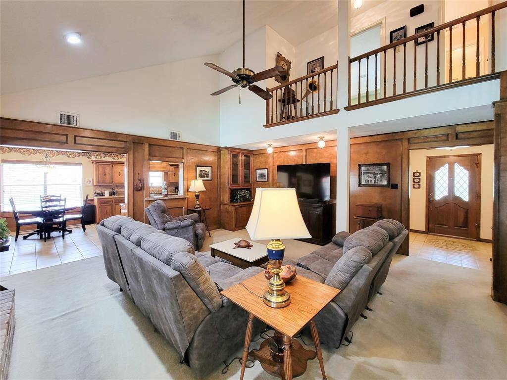 The living room is accentuated with wood paneling and a loft view, creating a warm and inviting atmosphere.