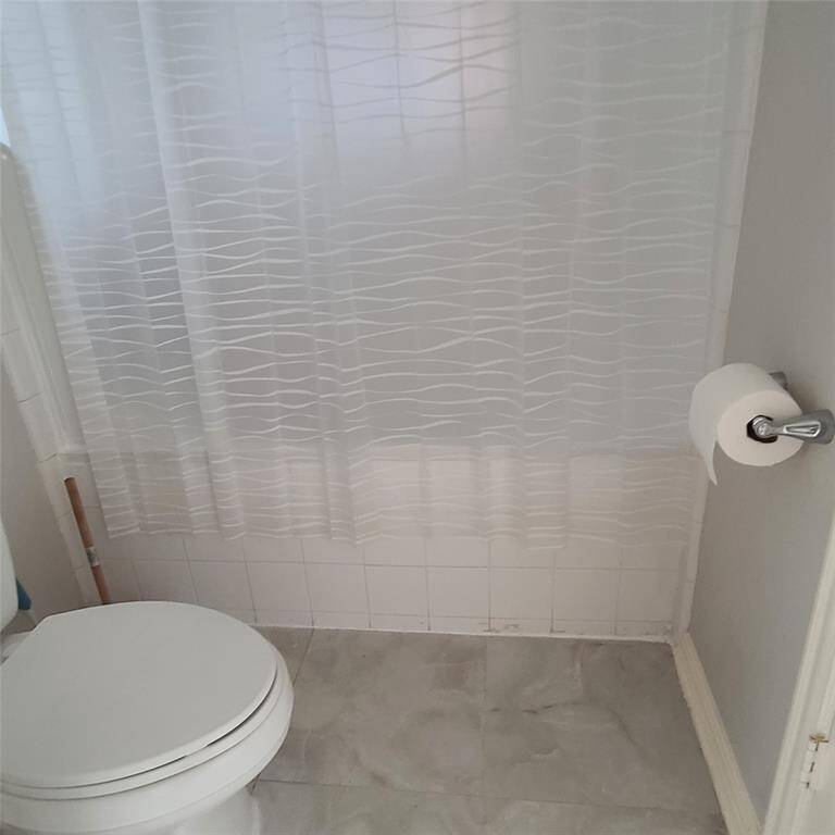 Tile floors, white tile & full bath tub with shower