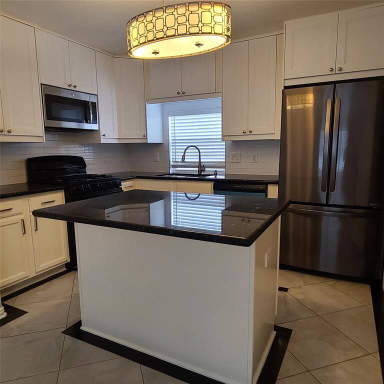 Island kitchen features updated granite counters