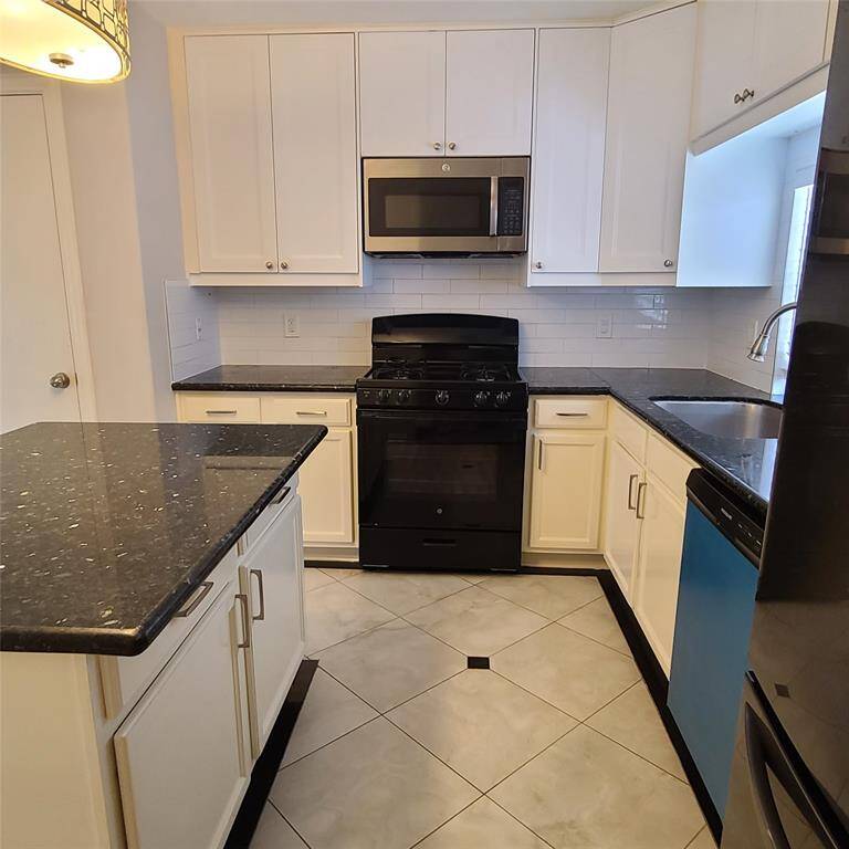 Gas range plus clean white cabinetry & pantry