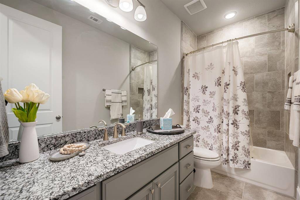 This is the 2nd full secondary bath on the first floor - lots of storage, tiled tub/shower combo, and granite countertop.