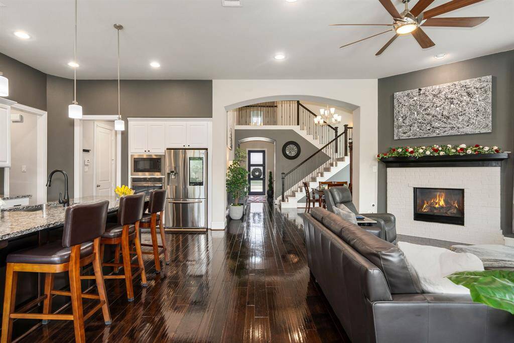 This desired floor plan is 1 1/2 stories and will sure impress even the pickiest buyers. This home shows pride of ownership the minute you walk through the front door. All bedrooms are downstairs, with a full media room and 1/2 bath upstairs. The upstairs attic has dead space to possibly build out another bedroom if needed. Hardwood floors throughout all common spaces. The view to the front door shows the living room with cozy gas fireplace, kitchen, and the open concept floor plan.