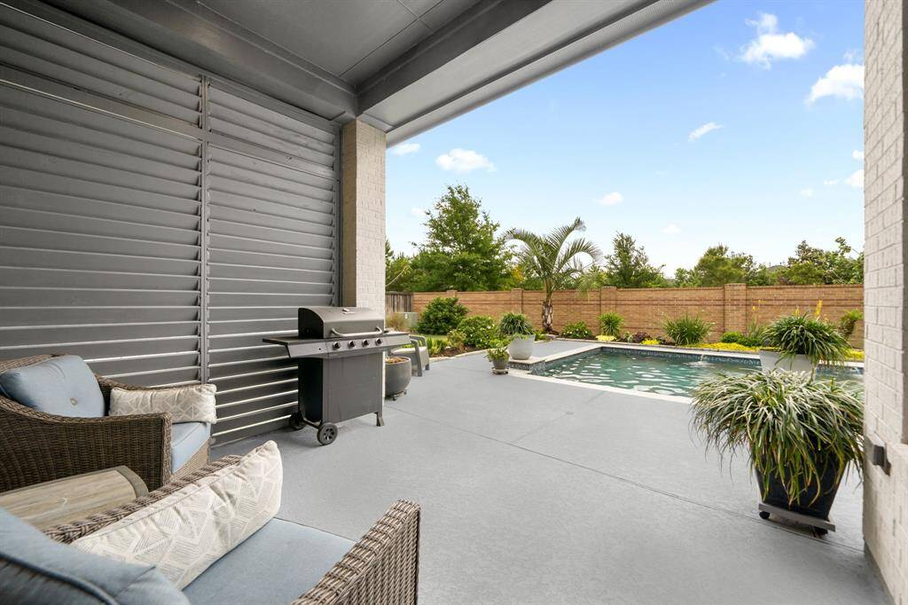 Let's step outside to the backyard oasis. Sit and marvel at the landscape and pool. Lots of privacy in this yard - no back neighbors (backs to an interior neighborhood road separated by a walkway) and a privacy shutter wall.