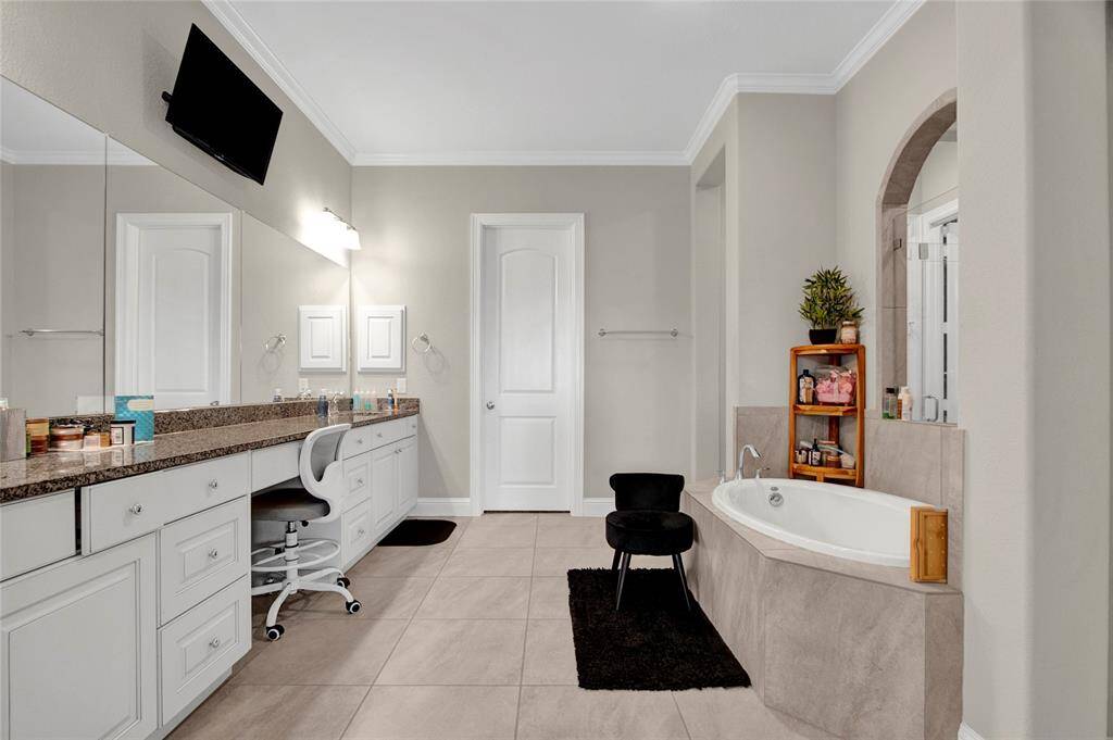 Elegant primary bath features crown molding, recessed lighting, and dual walk-in closets, offering a perfect blend of comfort and sophistication.