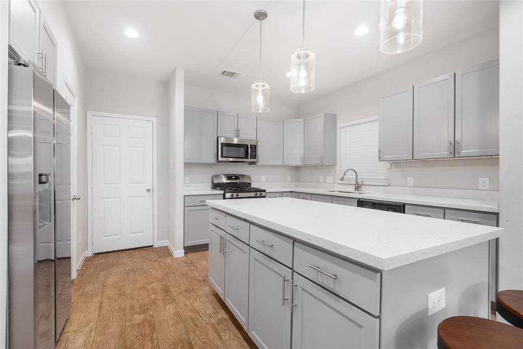 With a pantry, light gray cabinets, you will never need more storage space! Sophisticated touches like pendant lighting, white quartz counters and recessed lighting elevate this truly great space!