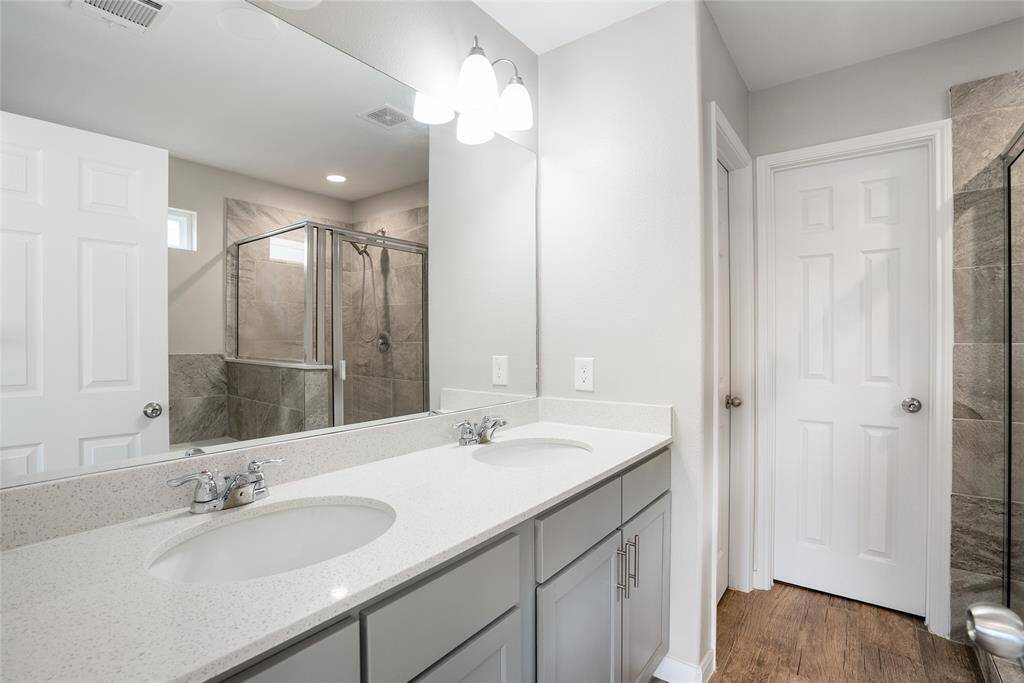 This crisp and clean primary bathroom is equipped with double sinks, ample storage, and separate shower and soaking tub!