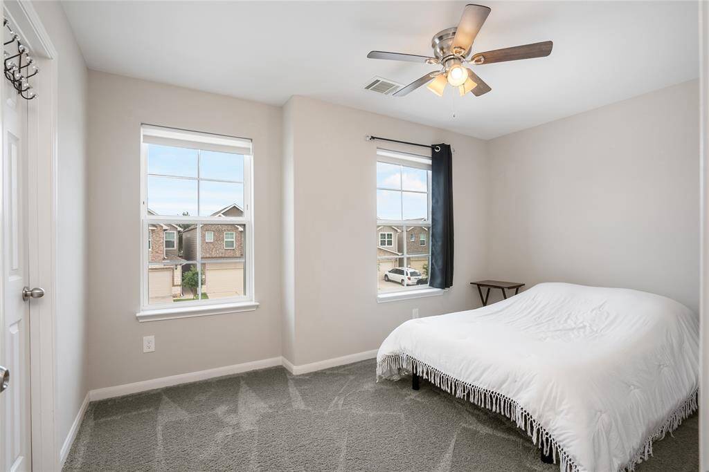 On the opposite side of the primary are two spacious secondary bedrooms, equipped with ceiling fans and bright windows.