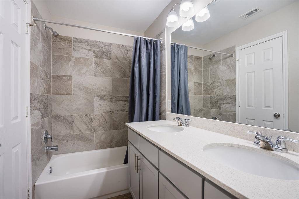 The secondary bathroom also has dual sinks and a tile-lined tub and shower area!