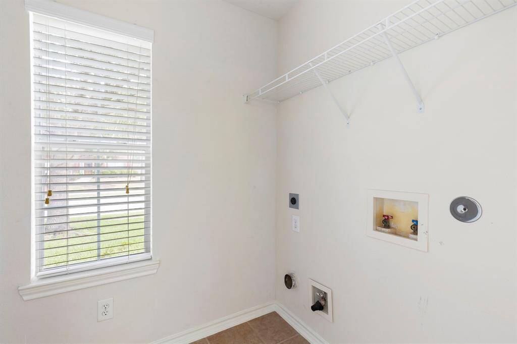 Utility room has shelving on the other side, great for extra storage.