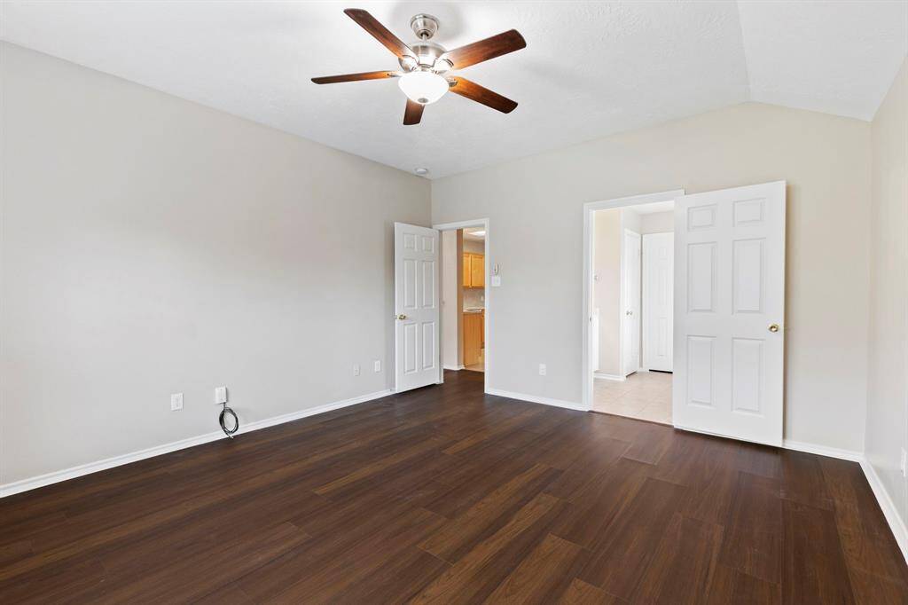 The primary suite features high vaulted ceilings and backyard views.