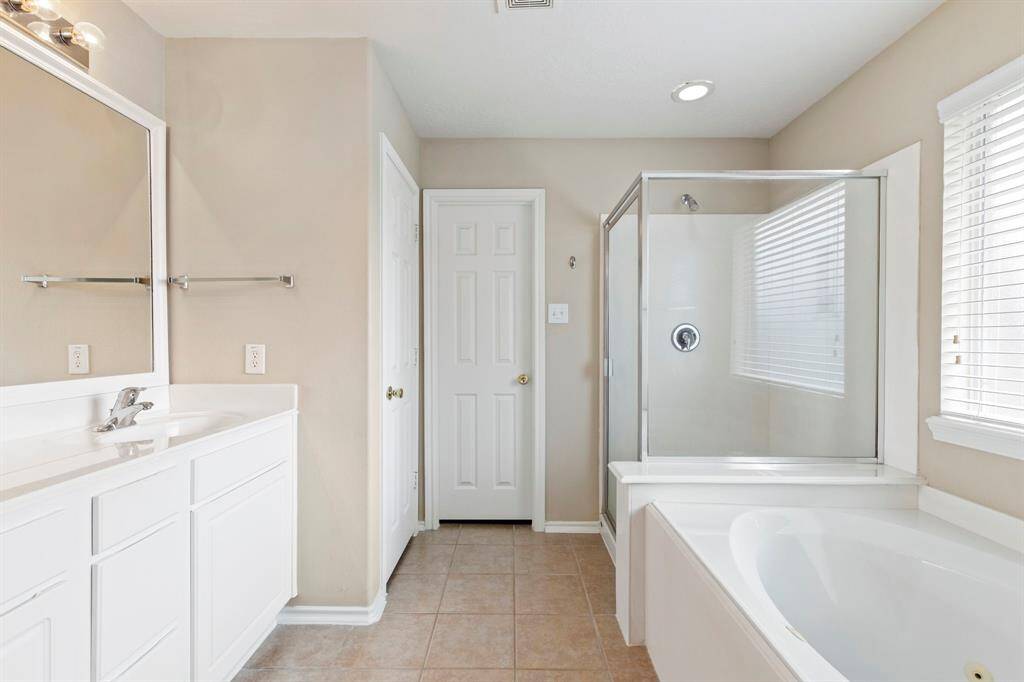 Primary bathroom with double sinks, jacuzzi tub and separate shower.