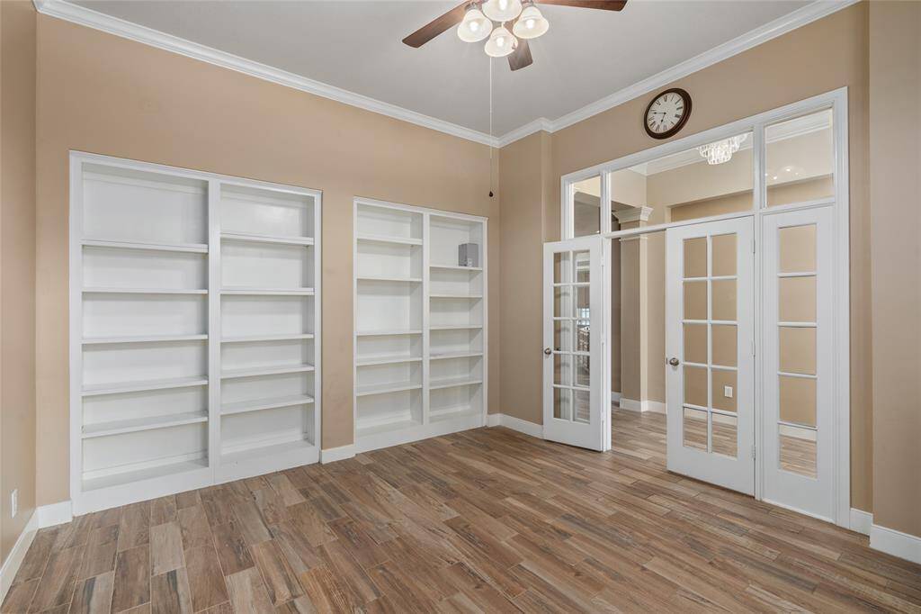 From this angle, you can appreciate the detailed built-in cabinets, offering both style and storage, along with the French doors that provide a glimpse into the hallway. This thoughtful layout allows for both openness and privacy, making it the perfect space for work or relaxation.perfect for relaxing evenings or gathering with family and friends.